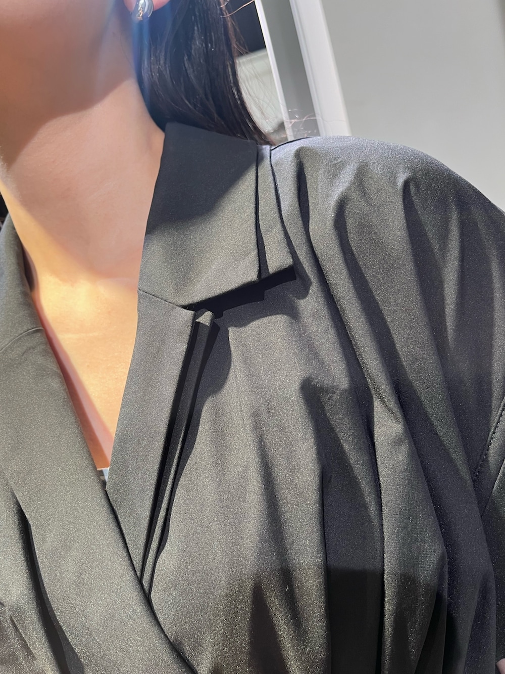 ブラック系のワンピース、ブラウン系のハンドバッグ、シルバー系のパンプスを着用したレディースの春コーディネートの4枚目の写真