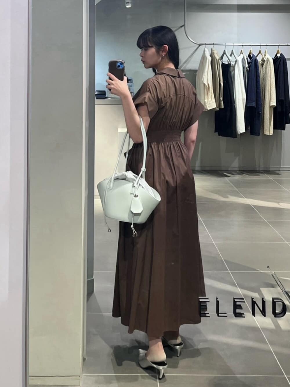 シルバー系のパンプス、ブラウン系のワンピース、グリーン系のトートバッグを着用したレディースの春コーディネートの3枚目の写真