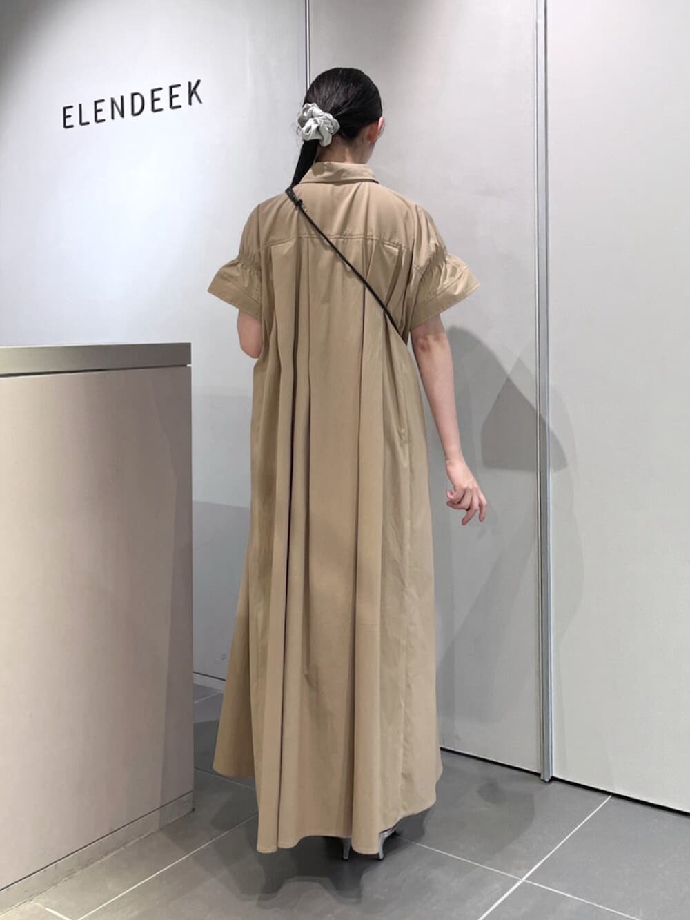 シルバー系のパンプス、ベージュ系のワンピース、ブラック系のスマホグッズを着用したレディースの夏コーディネートの4枚目の写真
