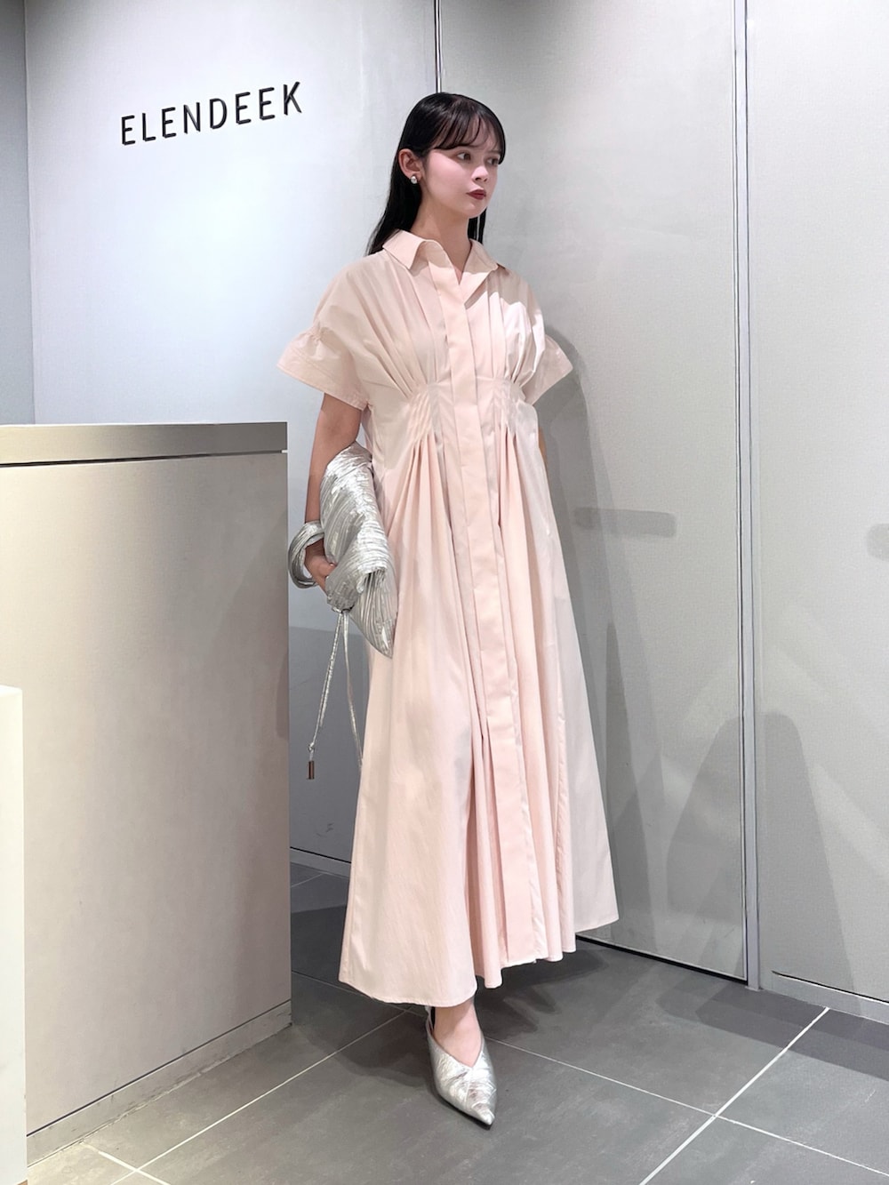 シルバー系のトートバッグ、シルバー系のパンプス、ピンク系のワンピースを着用したレディースの夏コーディネートの5枚目の写真