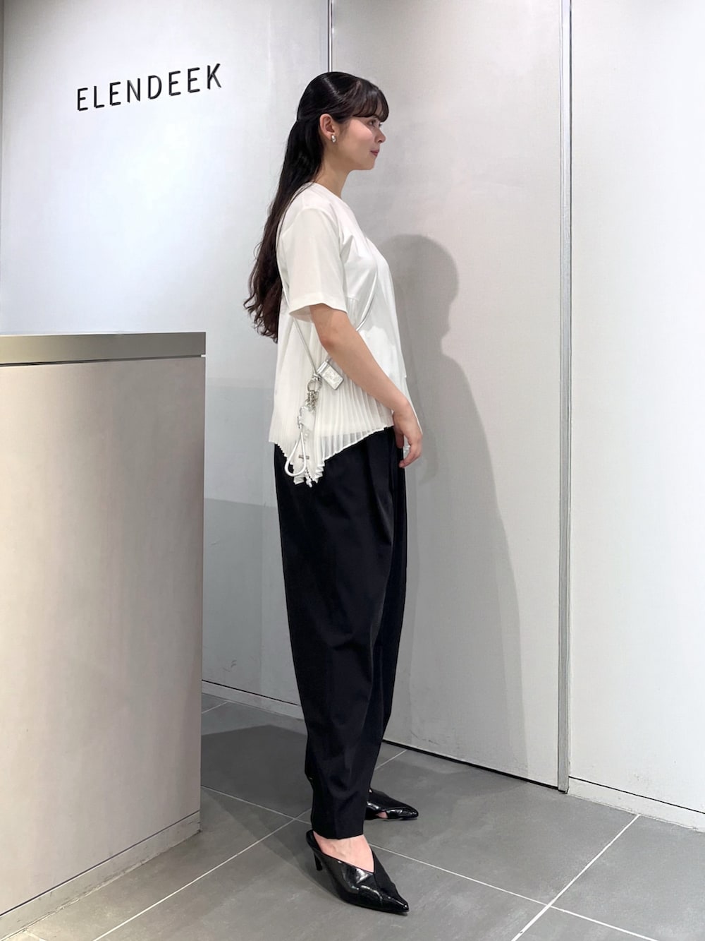 ホワイト系のTシャツ/カットソー、ブラック系のその他パンツ、ブラック系のパンプスを着用したレディースの夏コーディネートの2枚目の写真
