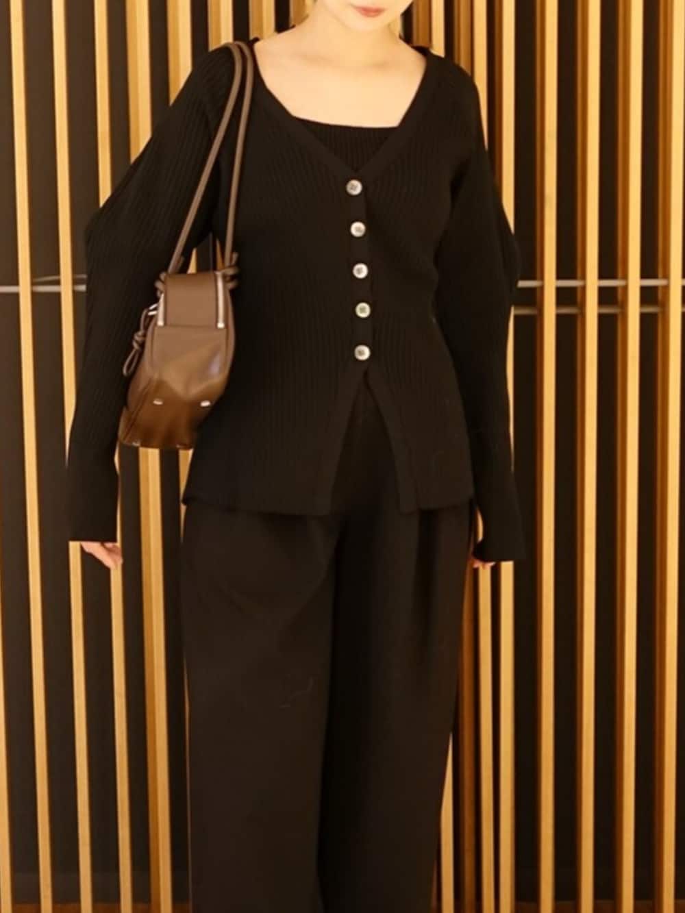ブラック系のカーディガン/ボレロ、ブラック系のその他パンツ、ブラウン系のボストンバッグを着用したレディースの秋コーディネートの5枚目の写真