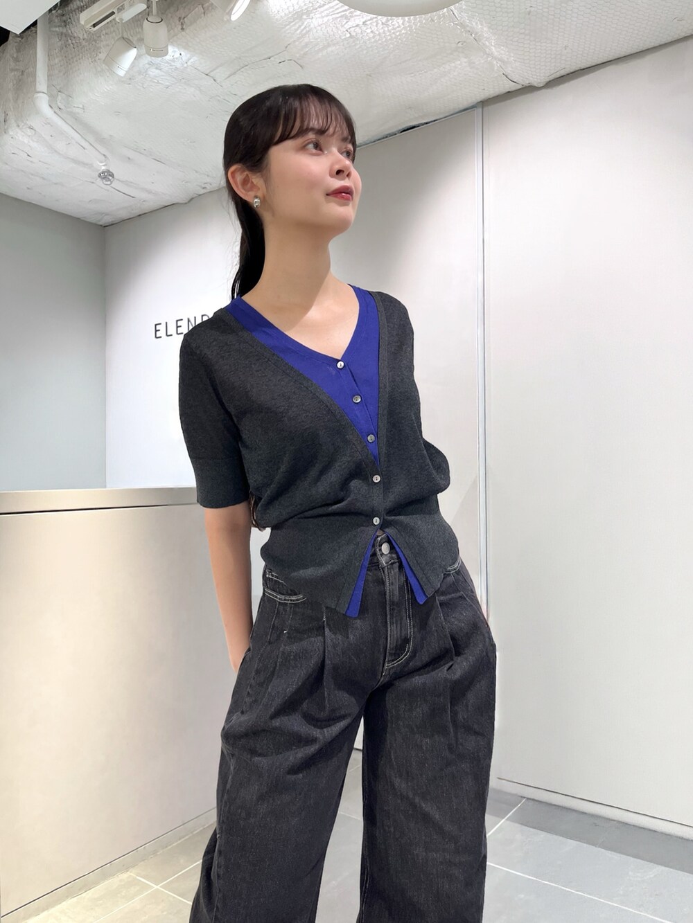 グレー系のニット/セーター、ブラック系のデニムパンツ、シルバー系のパンプスを着用したレディースの夏コーディネートの6枚目の写真
