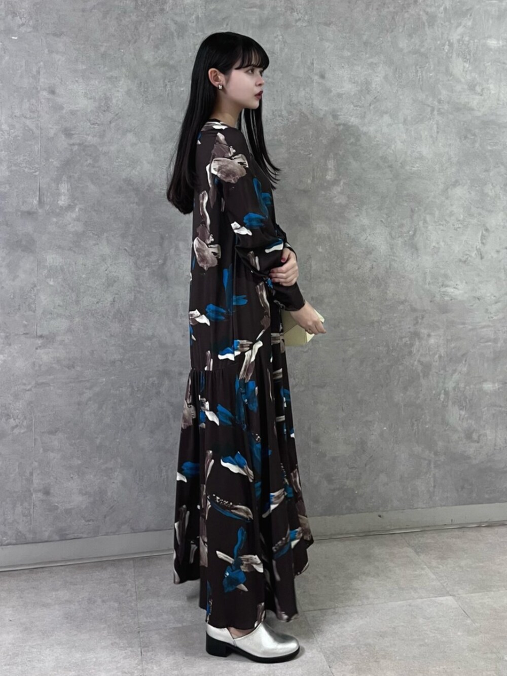 ブラウン系のワンピース、イエロー系のハンドバッグ、シルバー系のパンプスを着用したレディースの秋コーディネートの6枚目の写真