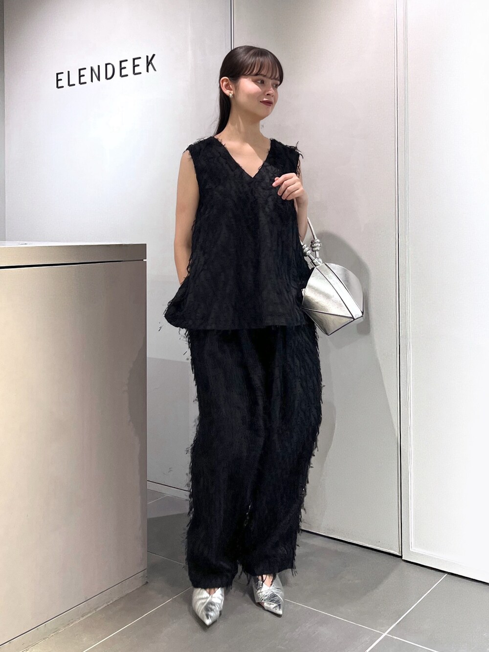 ブラック系のシャツ/ブラウス、ブラック系のその他パンツ、シルバー系のパンプスを着用したレディースの夏コーディネートの4枚目の写真