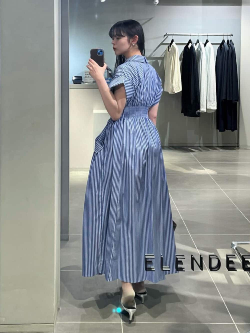 シルバー系のパンプス、その他のワンピース、ブラウン系のトートバッグを着用したレディースの春コーディネートの3枚目の写真