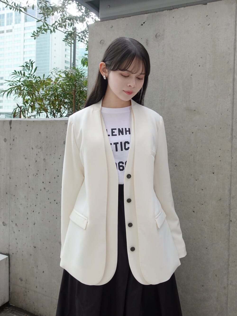 ホワイト系のノーカラージャケット、ホワイト系のTシャツ/カットソー、ブラック系のスカートを着用したレディースの春コーディネートの4枚目の写真