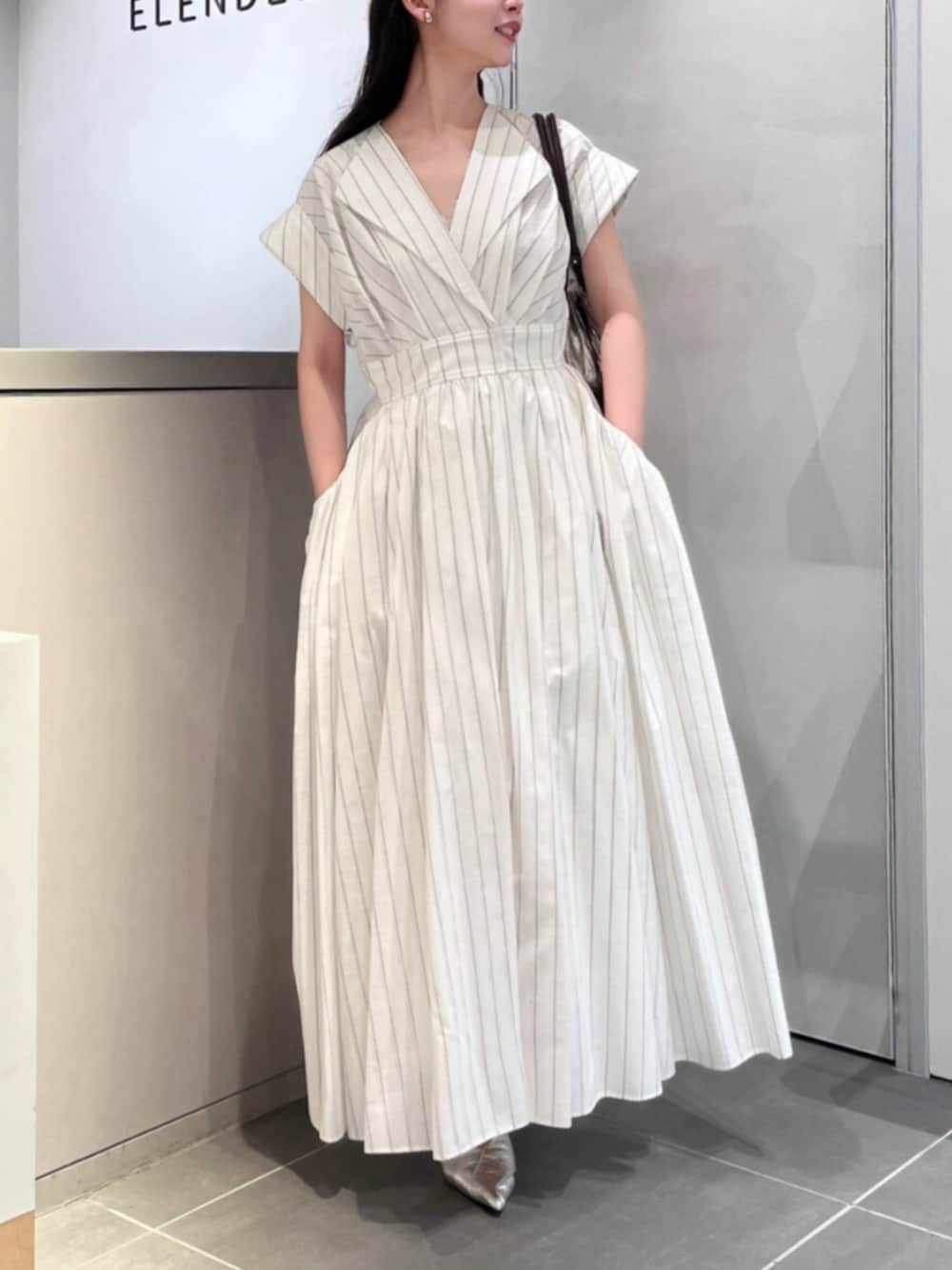 シルバー系のパンプス、ブラウン系のトートバッグ、その他のワンピースを着用したレディースの夏コーディネートの5枚目の写真