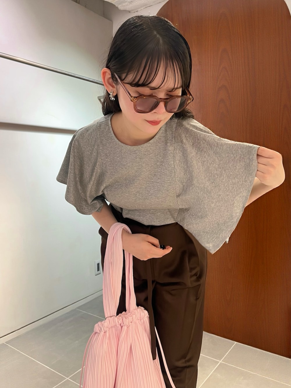 グレー系のTシャツ/カットソー、ブラウン系のその他パンツ、ピンク系のトートバッグを着用したレディースの夏コーディネートの5枚目の写真