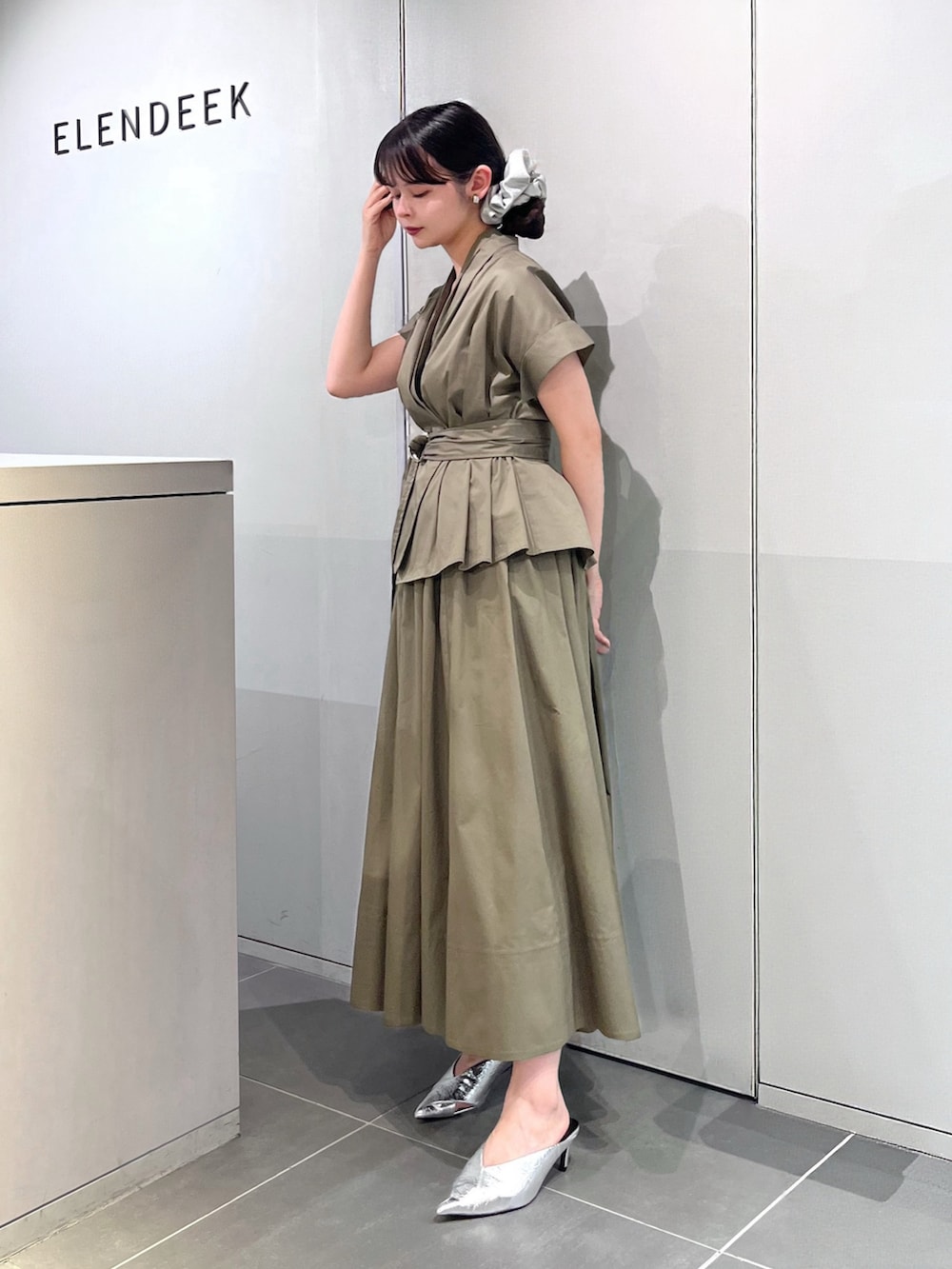 シルバー系のパンプス、グリーン系のワンピース、シルバー系のシュシュを着用したレディースの夏コーディネートの5枚目の写真