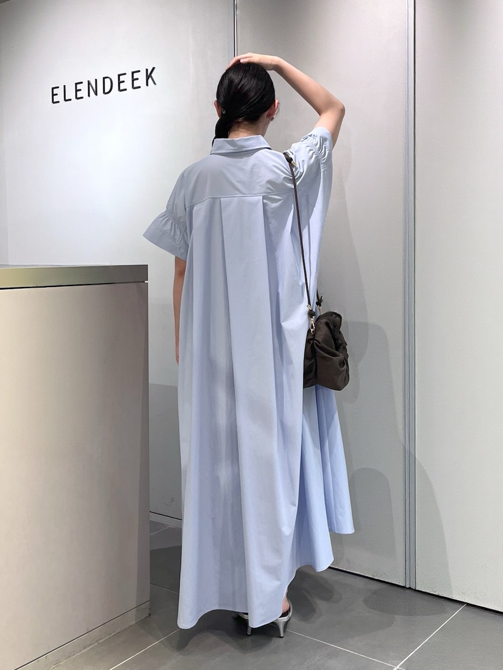 シルバー系のパンプス、ブラウン系のハンドバッグ、ブルー系のワンピースを着用したレディースの夏コーディネートの3枚目の写真