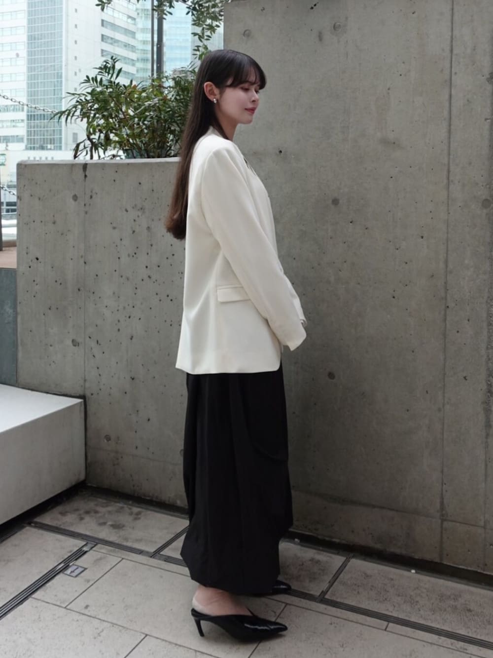 ホワイト系のノーカラージャケット、ホワイト系のTシャツ/カットソー、ブラック系のスカートを着用したレディースの春コーディネートの2枚目の写真