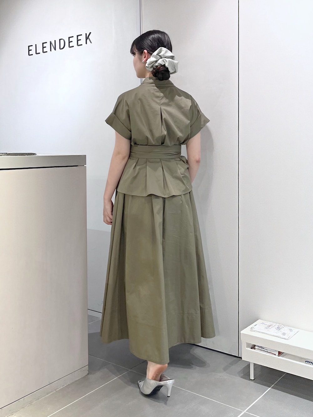 シルバー系のパンプス、グリーン系のワンピース、シルバー系のシュシュを着用したレディースの夏コーディネートの3枚目の写真