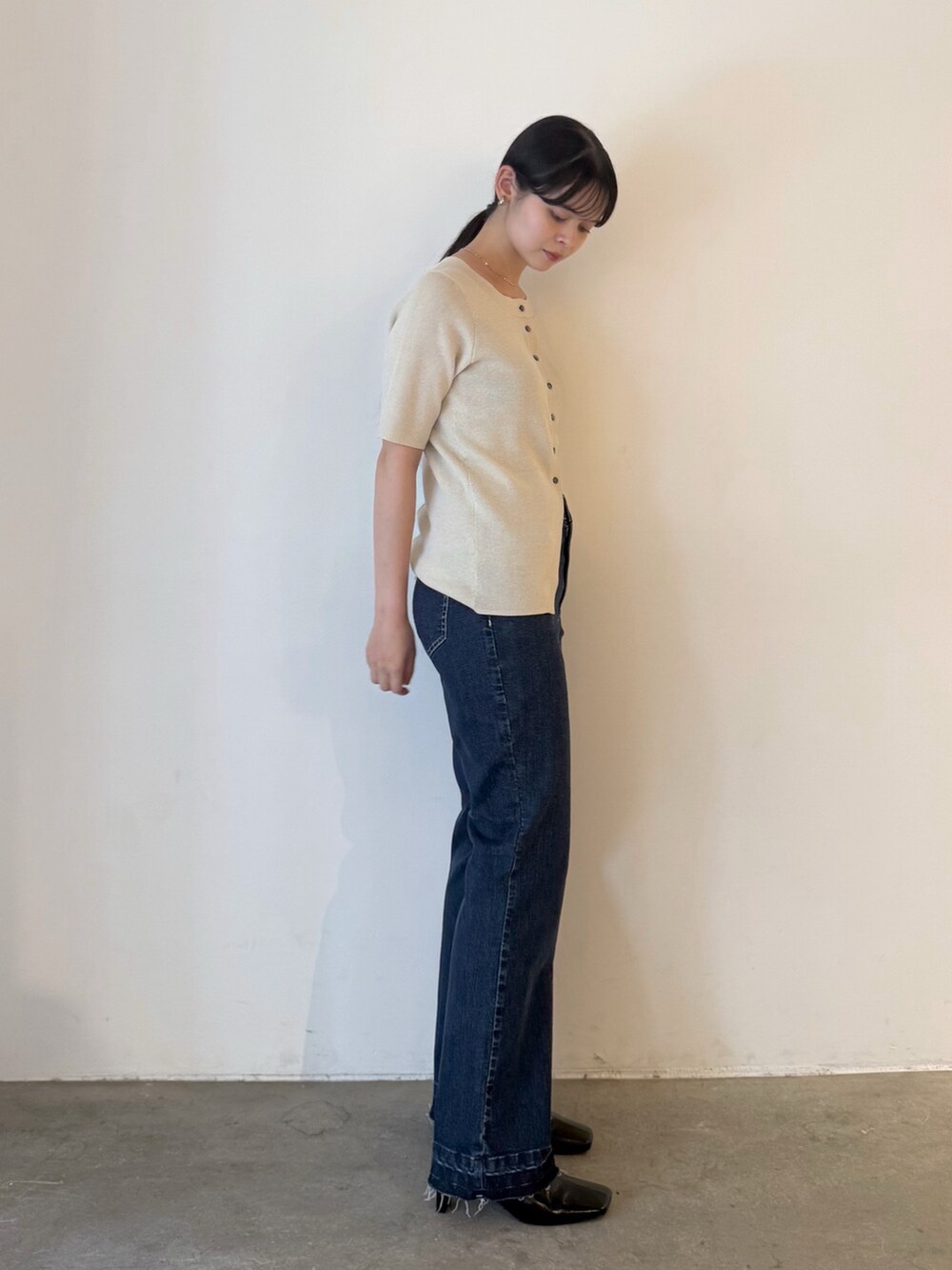 ベージュ系のカーディガン/ボレロ、ブルー系のデニムパンツ、ブラック系のブーツを着用したレディースの夏コーディネートの10枚目の写真