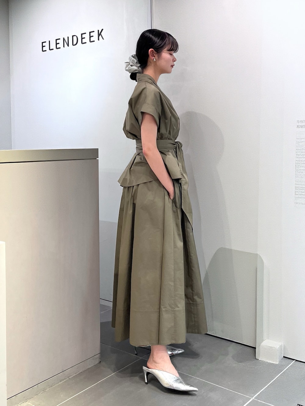 シルバー系のパンプス、グリーン系のワンピース、シルバー系のシュシュを着用したレディースの夏コーディネートの2枚目の写真
