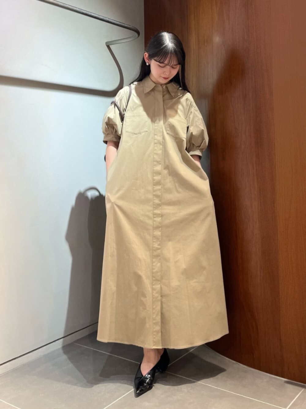 ブラック系のパンプス、ブラウン系のトートバッグ、ベージュ系のワンピースを着用したレディースの夏コーディネートの4枚目の写真