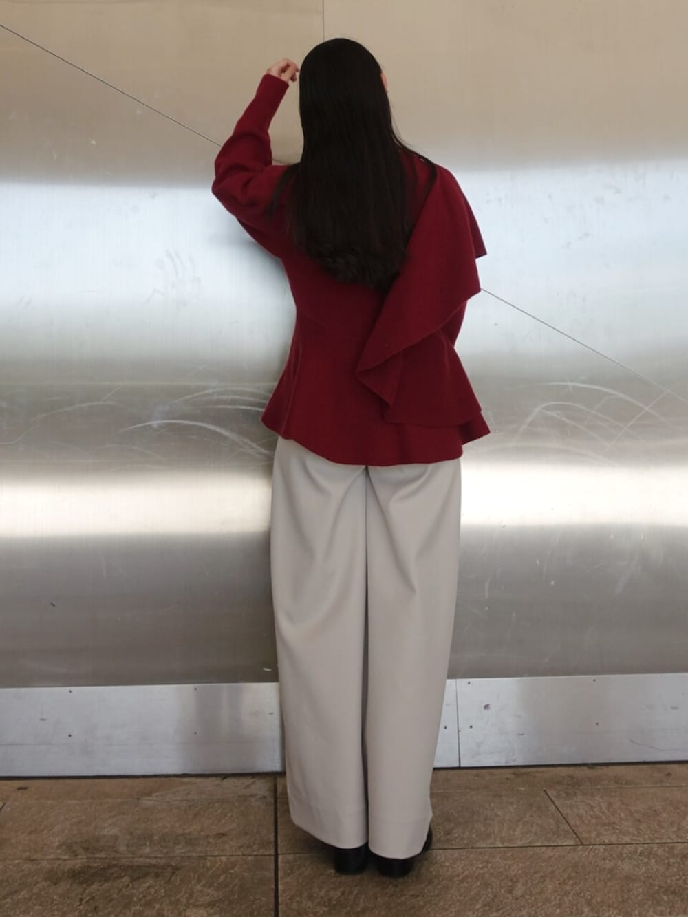 レッド系のニット/セーター、ホワイト系のその他パンツ、ブラック系のボストンバッグを着用したレディースの冬コーディネートの3枚目の写真