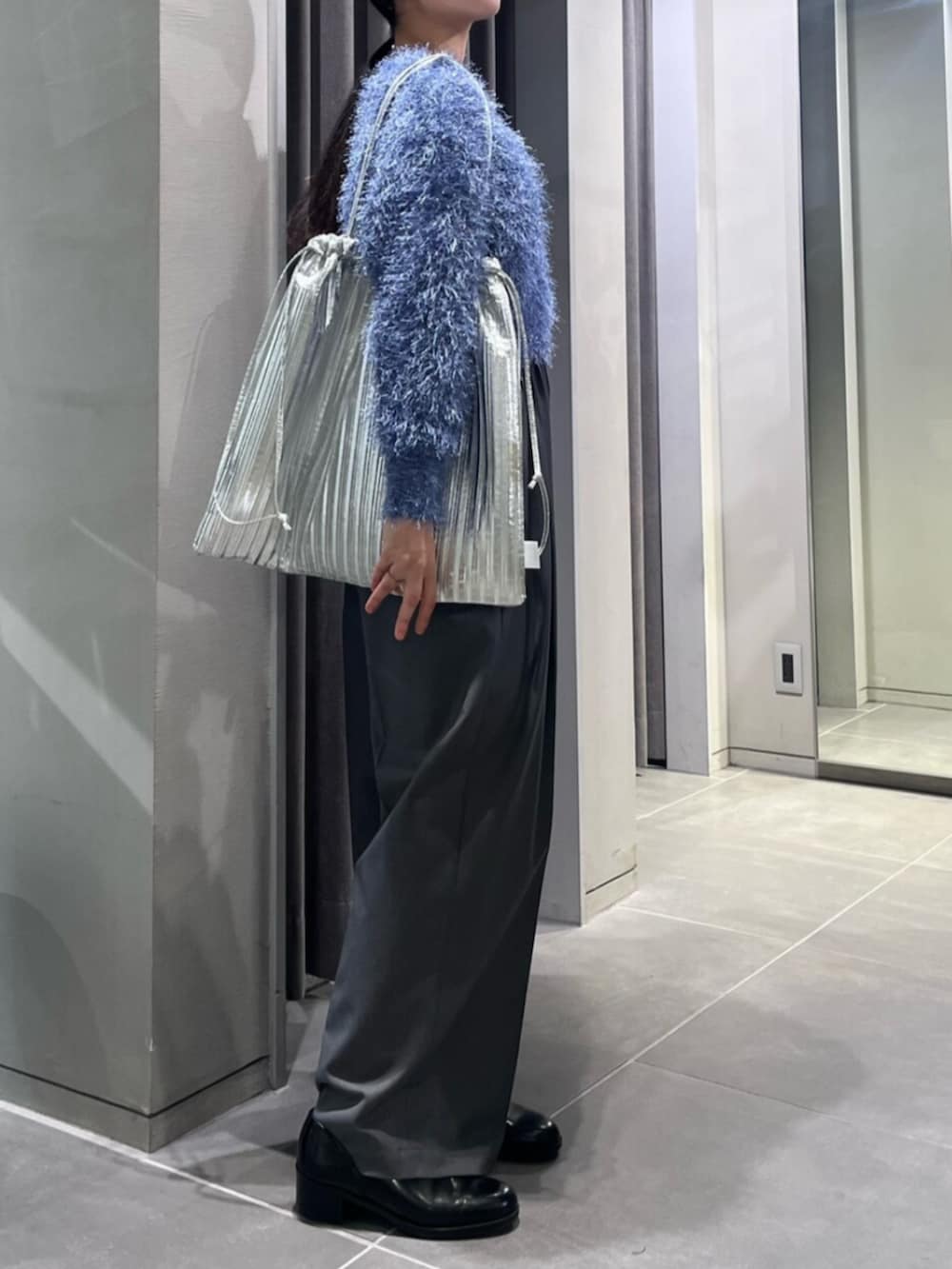 ブラック系のパンプス、ブルー系のニット/セーター、グレー系のその他パンツを着用したレディースの冬コーディネートの3枚目の写真