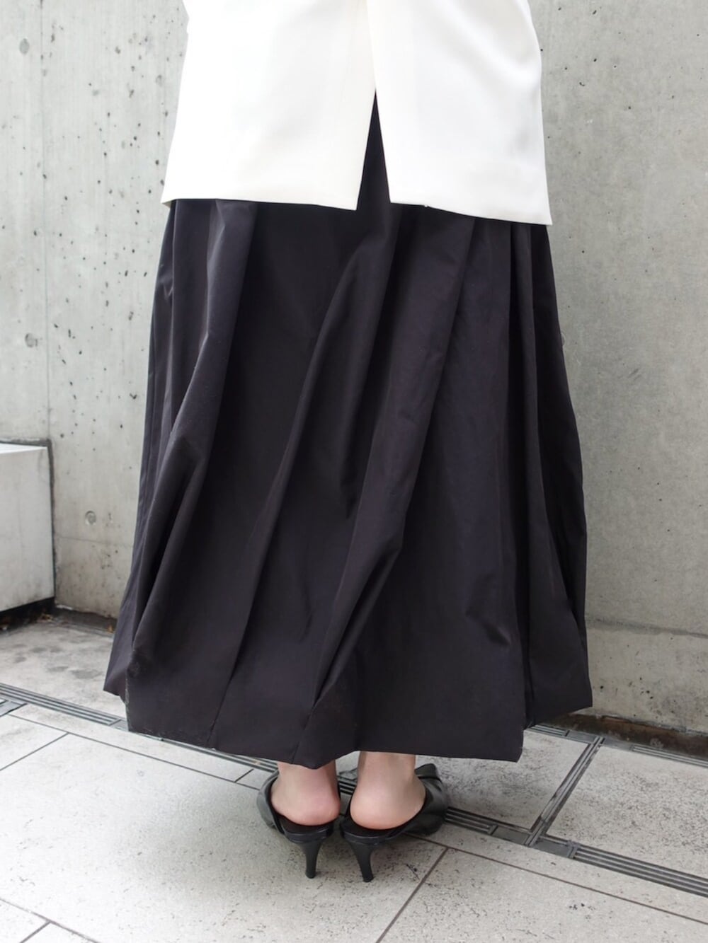 ホワイト系のノーカラージャケット、ホワイト系のTシャツ/カットソー、ブラック系のスカートを着用したレディースの春コーディネートの5枚目の写真