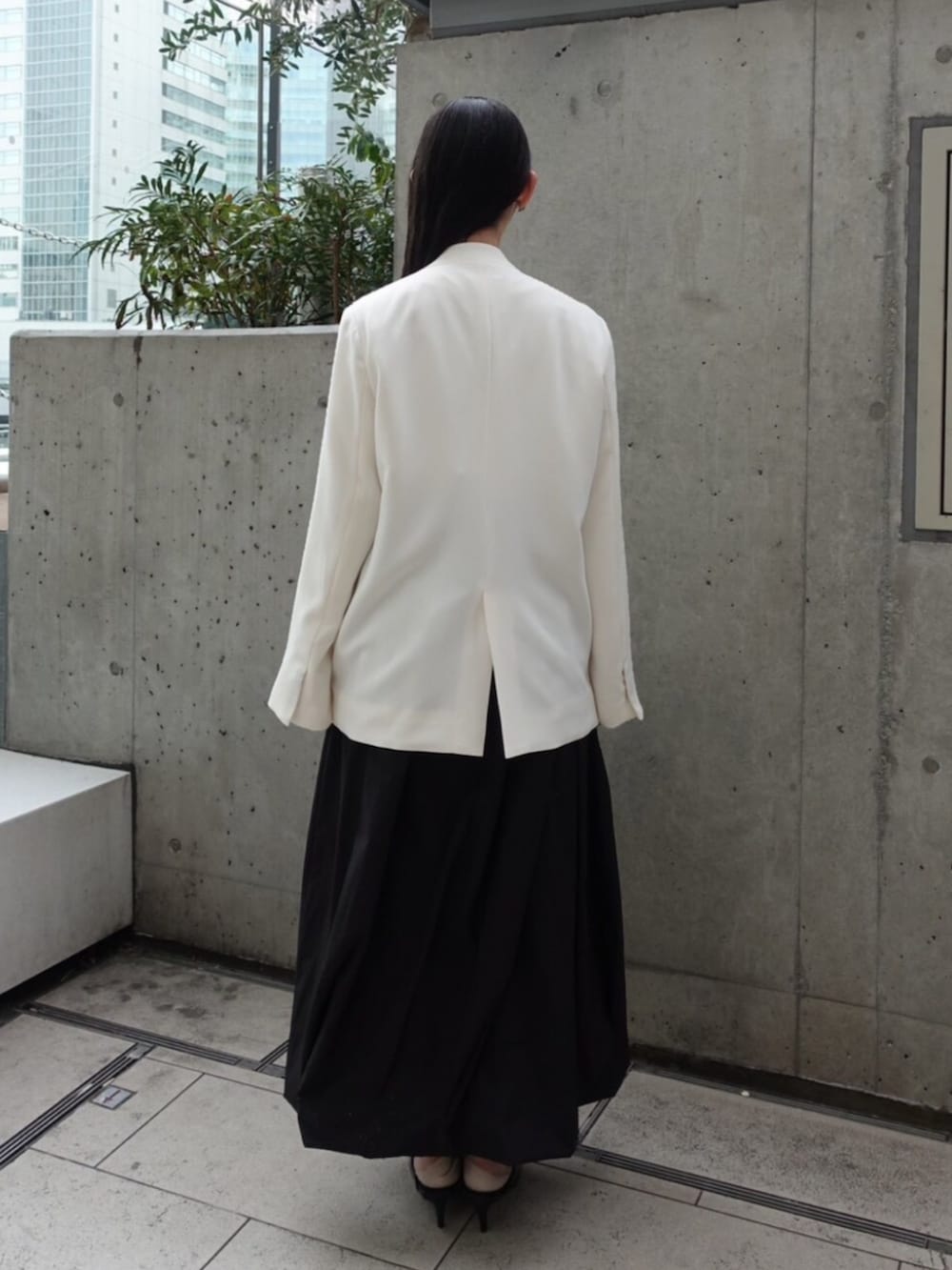 ホワイト系のノーカラージャケット、ホワイト系のTシャツ/カットソー、ブラック系のスカートを着用したレディースの春コーディネートの3枚目の写真