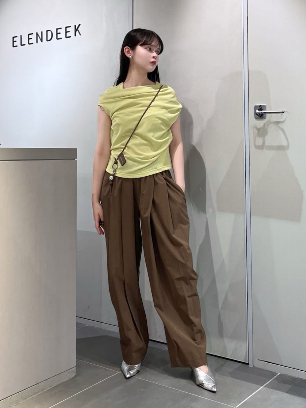 シルバー系のパンプス、グリーン系のTシャツ/カットソー、ブラウン系のその他パンツを着用したレディースの夏コーディネートの4枚目の写真