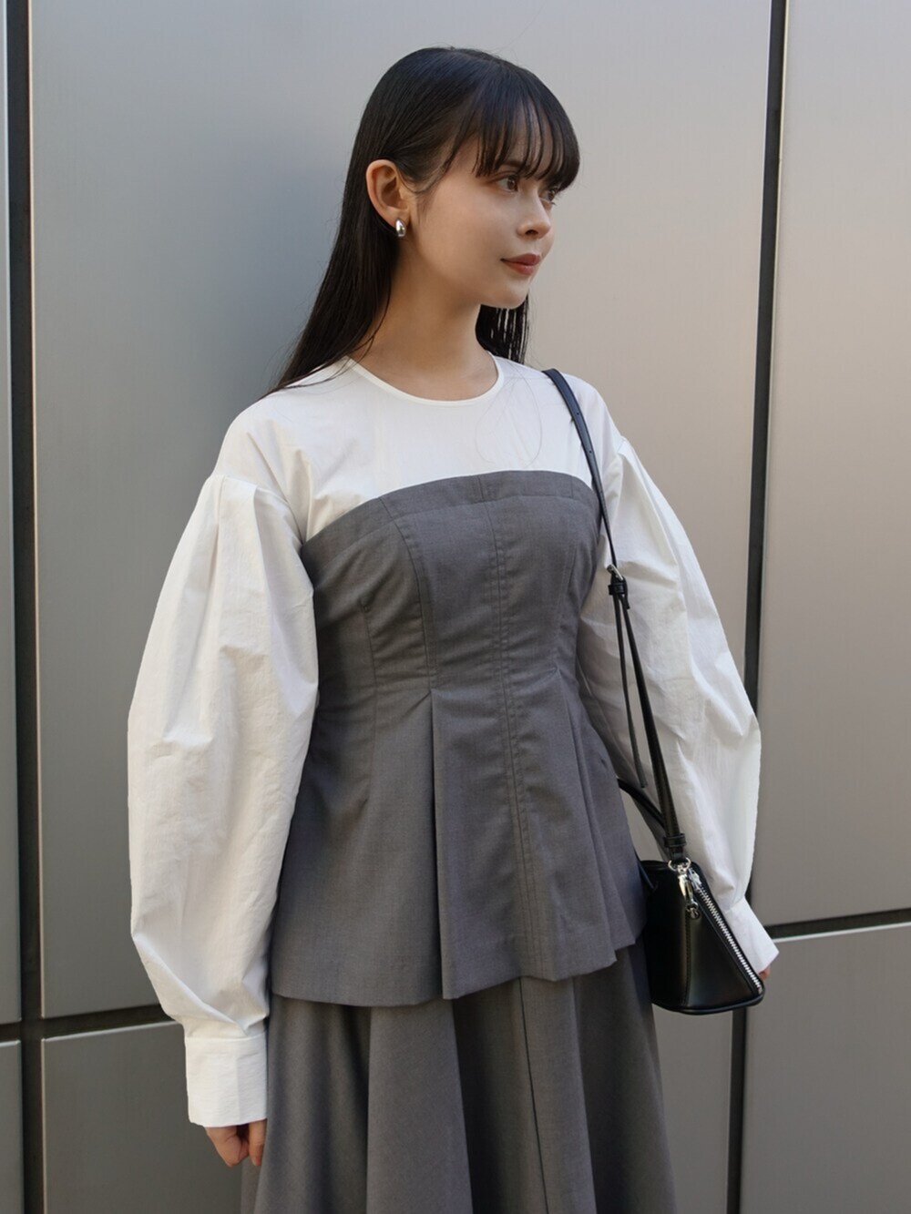ブラック系のボストンバッグ、グレー系のワンピース、ブラック系のパンプスを着用したレディースの冬コーディネートの5枚目の写真
