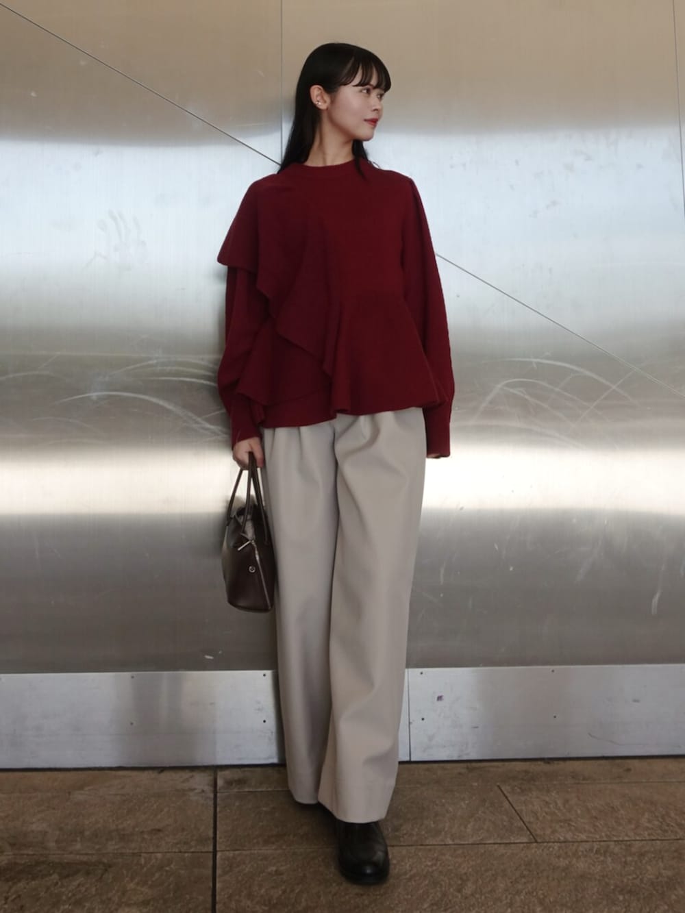 レッド系のニット/セーター、ホワイト系のその他パンツ、ブラック系のボストンバッグを着用したレディースの冬コーディネートの4枚目の写真