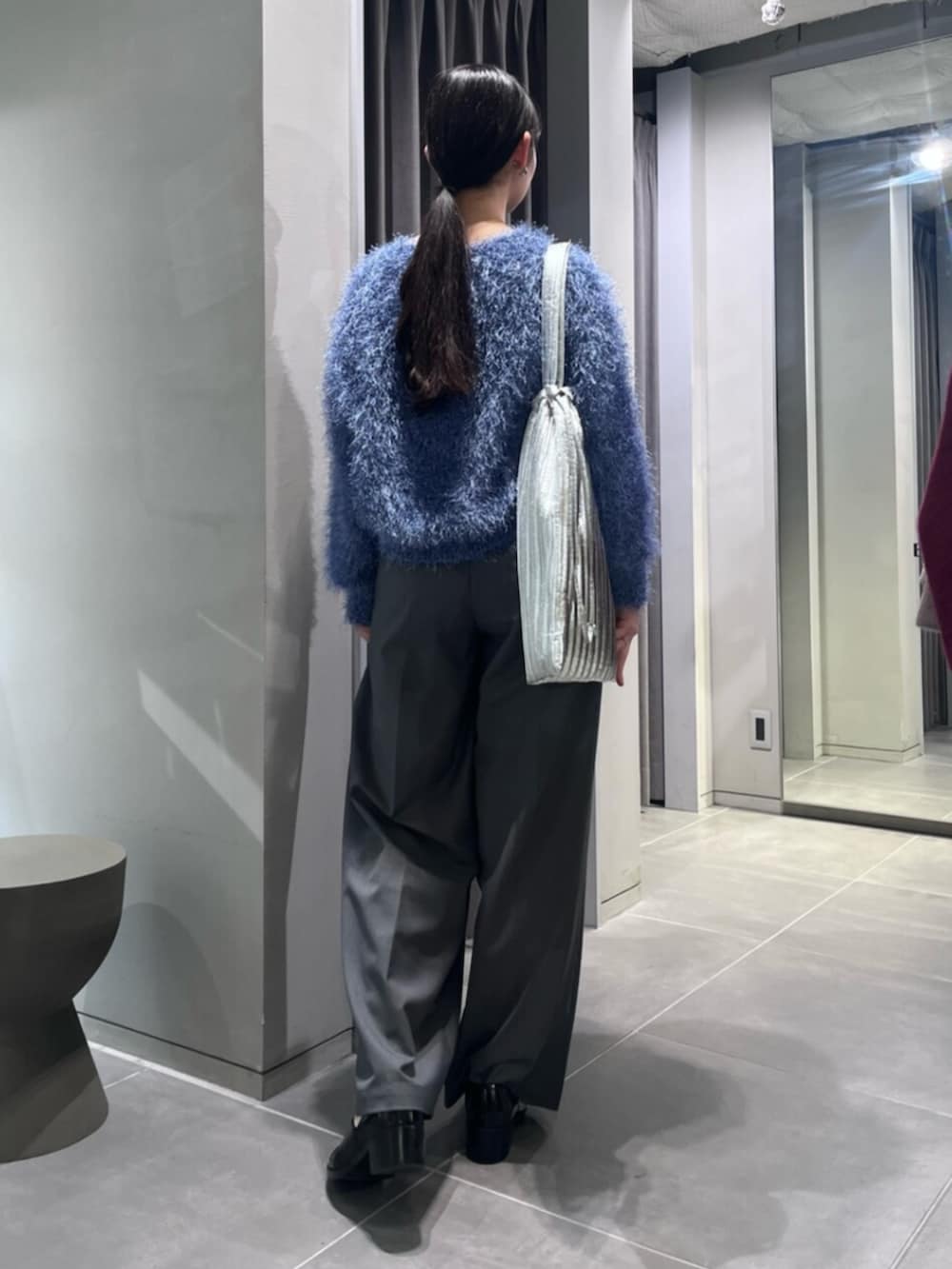 ブラック系のパンプス、ブルー系のニット/セーター、グレー系のその他パンツを着用したレディースの冬コーディネートの4枚目の写真