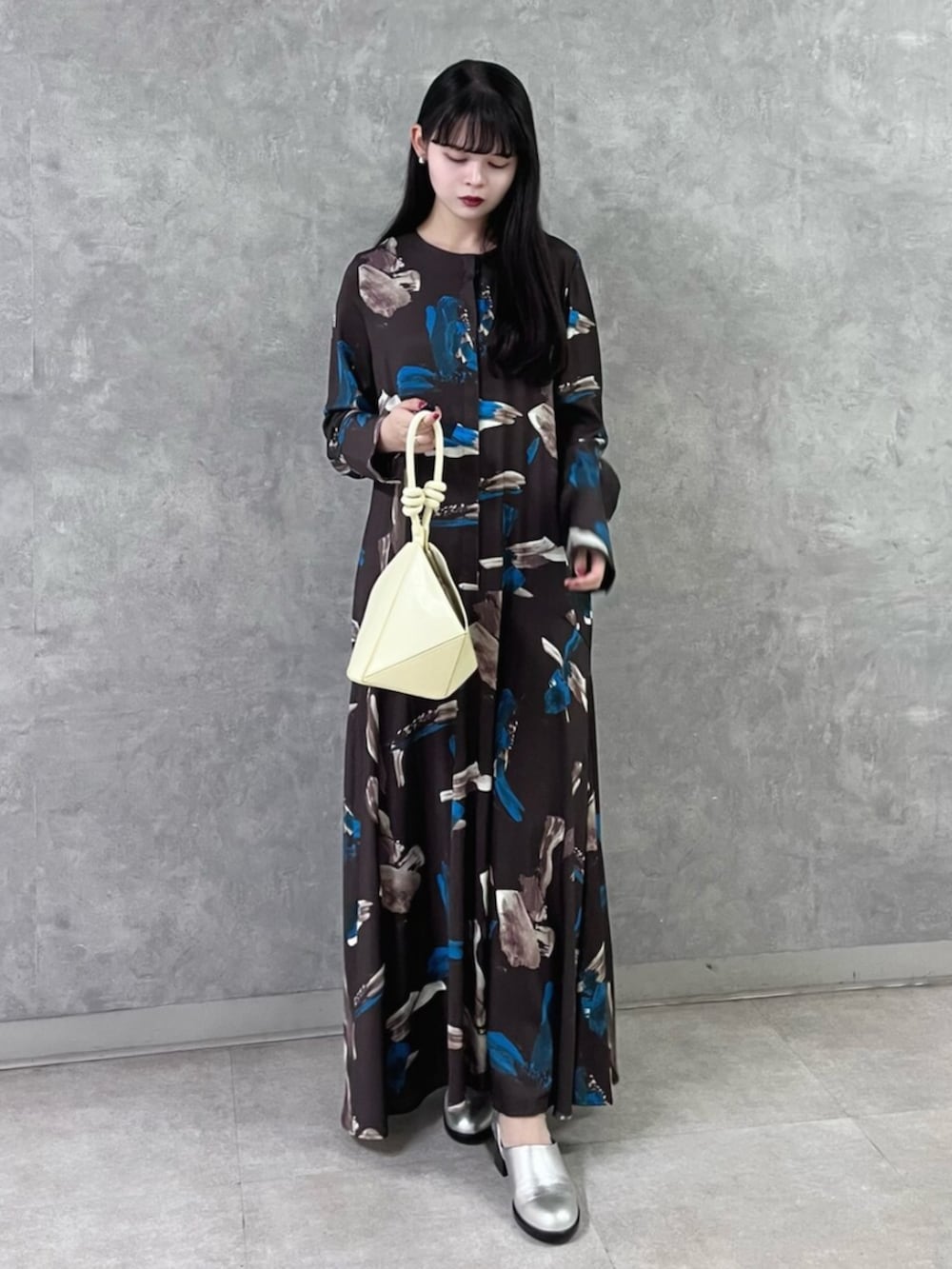 ブラウン系のワンピース、イエロー系のハンドバッグ、シルバー系のパンプスを着用したレディースの秋コーディネートの5枚目の写真