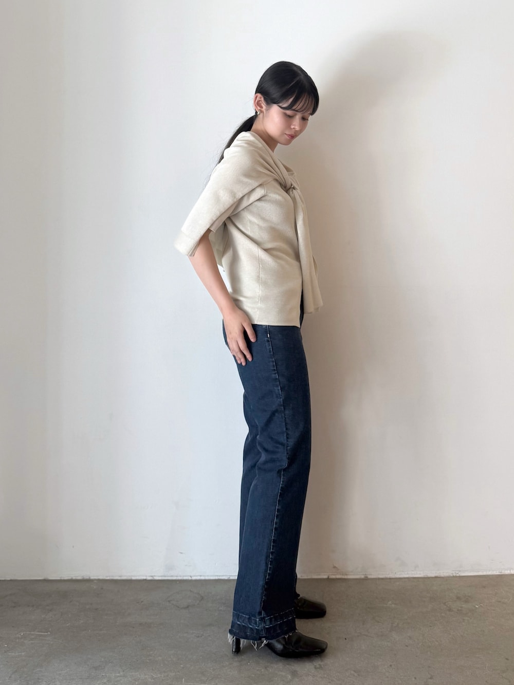 ベージュ系のカーディガン/ボレロ、ブルー系のデニムパンツ、ブラック系のブーツを着用したレディースの夏コーディネートの2枚目の写真
