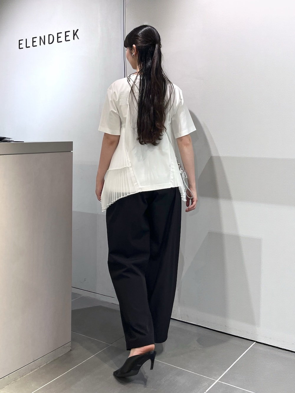 ホワイト系のTシャツ/カットソー、ブラック系のその他パンツ、ブラック系のパンプスを着用したレディースの夏コーディネートの3枚目の写真