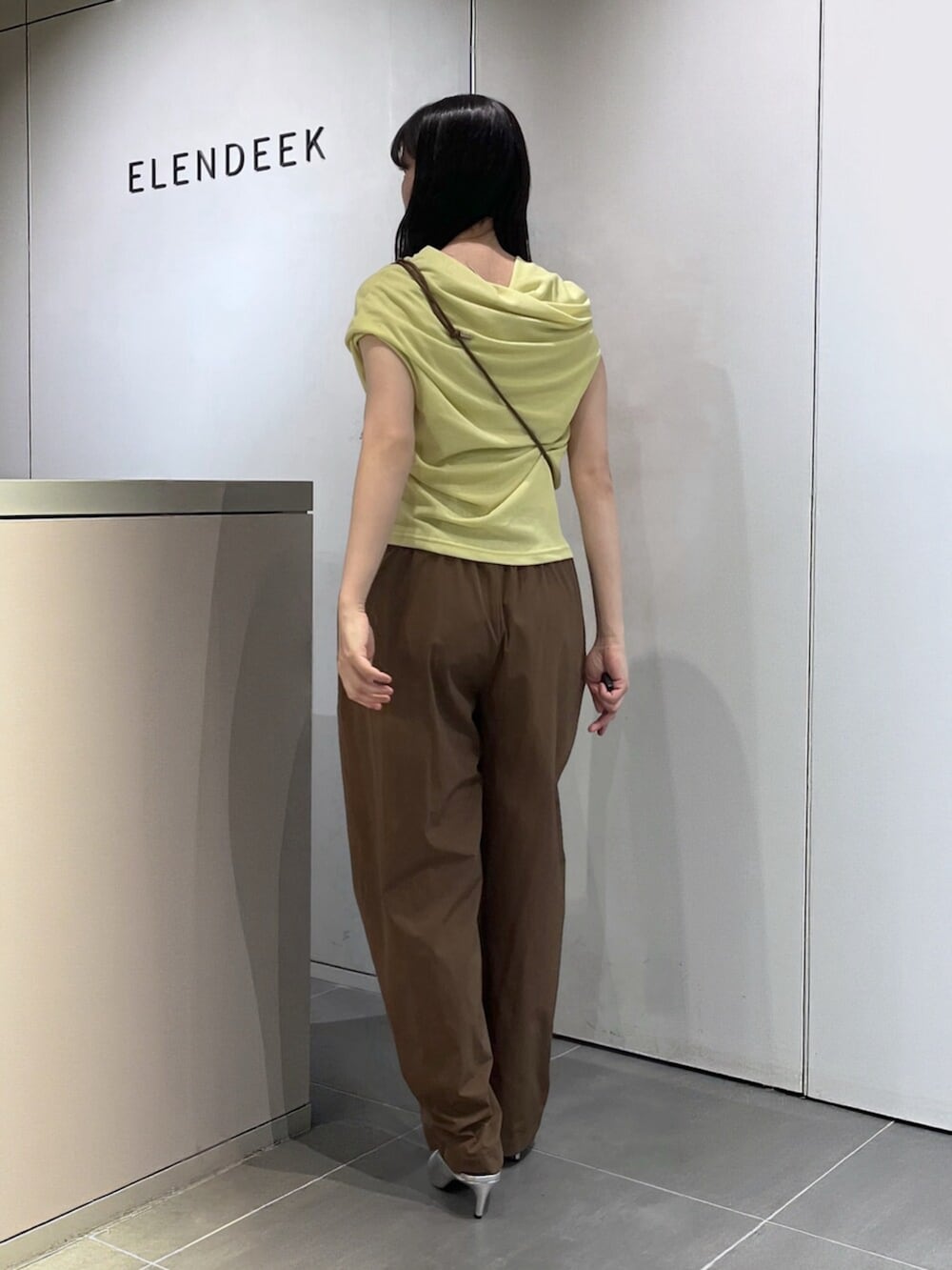 シルバー系のパンプス、グリーン系のTシャツ/カットソー、ブラウン系のその他パンツを着用したレディースの夏コーディネートの3枚目の写真