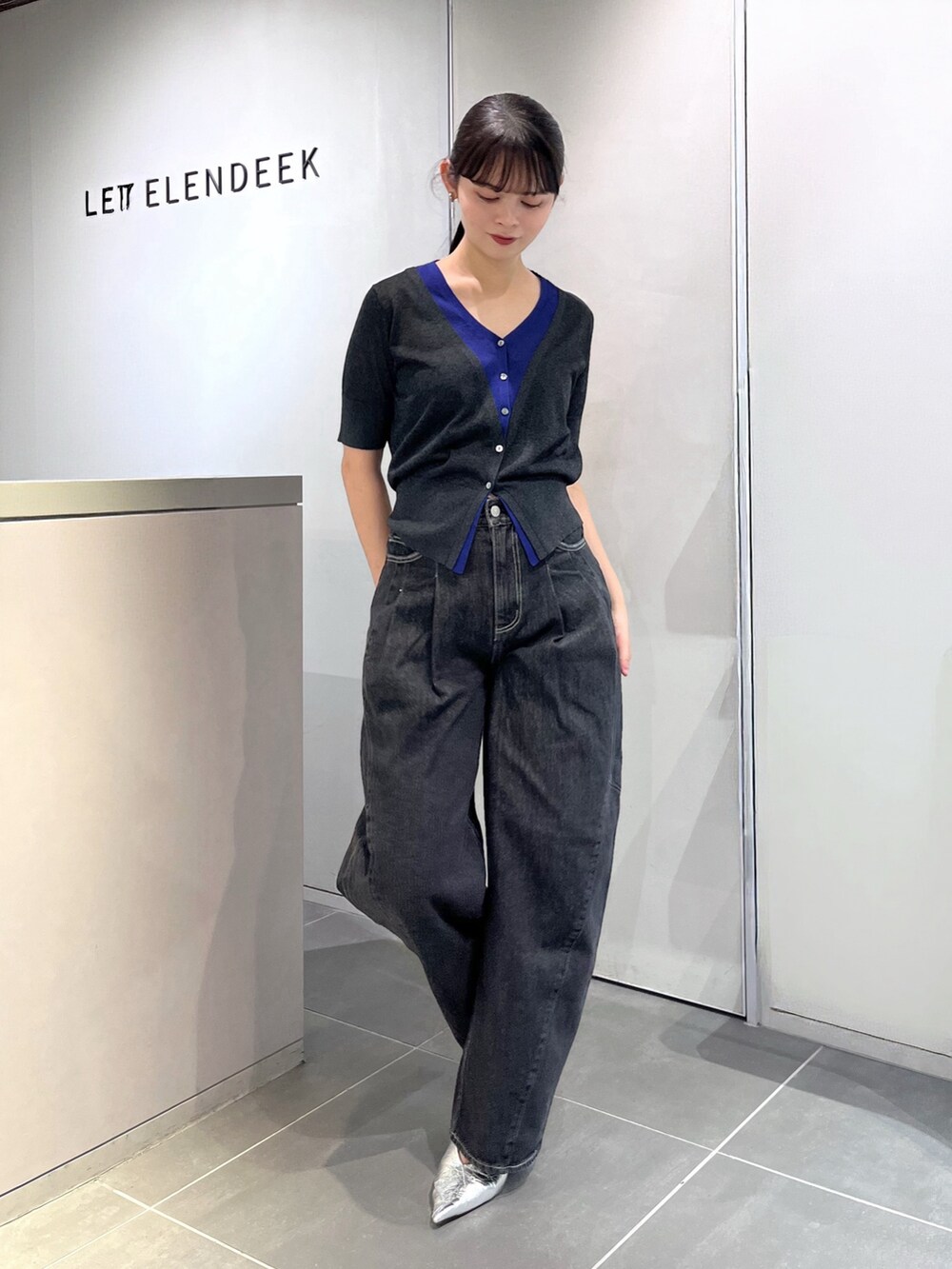 グレー系のニット/セーター、ブラック系のデニムパンツ、シルバー系のパンプスを着用したレディースの夏コーディネートの5枚目の写真