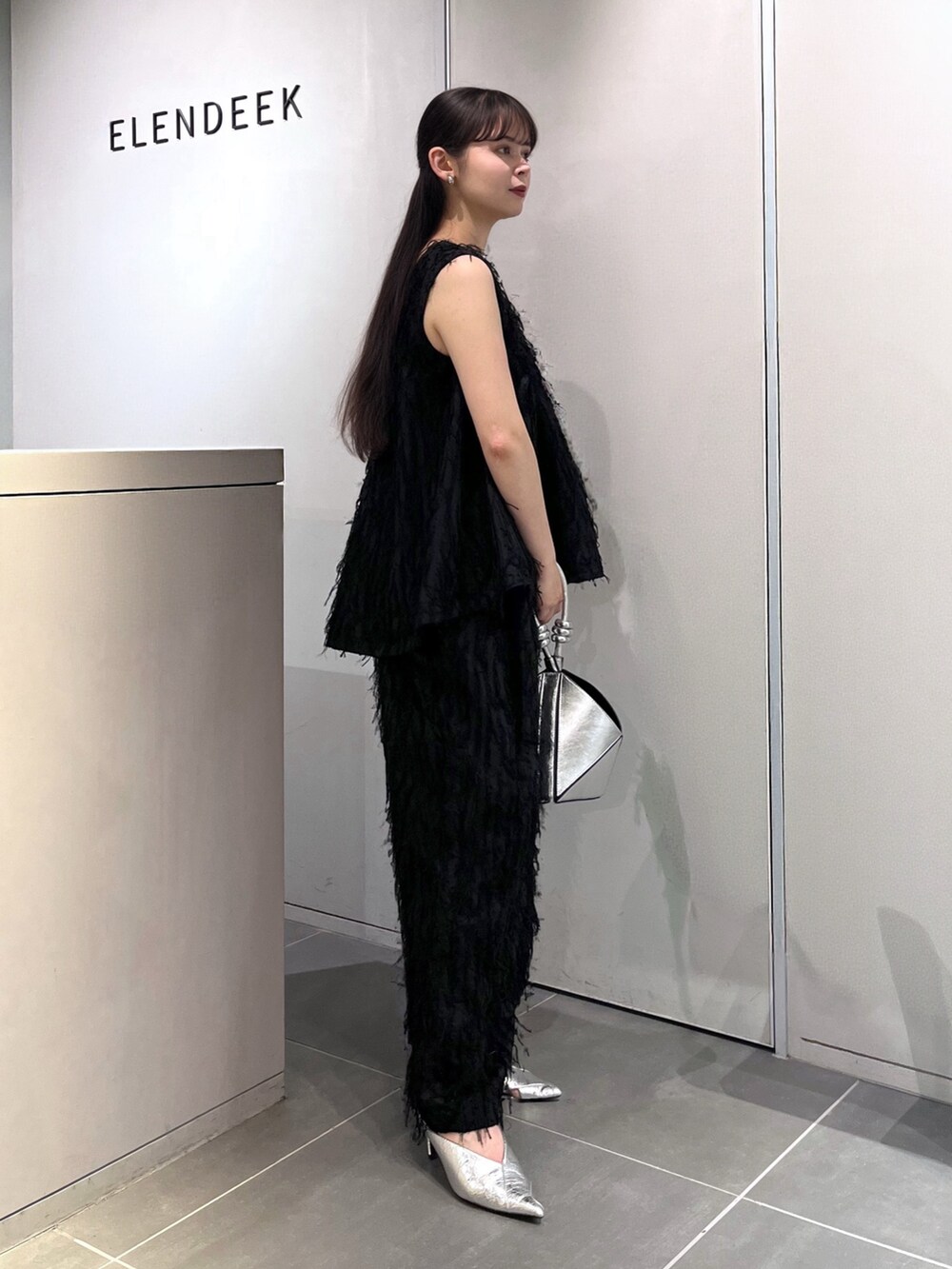 ブラック系のシャツ/ブラウス、ブラック系のその他パンツ、シルバー系のパンプスを着用したレディースの夏コーディネートの2枚目の写真