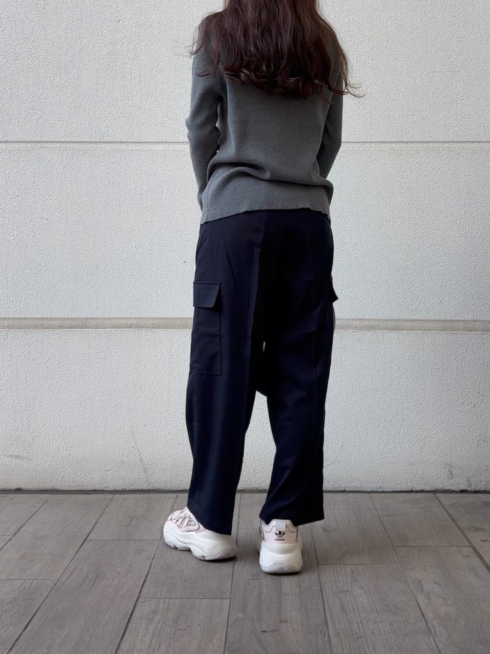 グレー系のハンドバッグ、グレー系のニット/セーター、ブルー系のその他パンツを着用したレディースの冬コーディネートの2枚目の写真