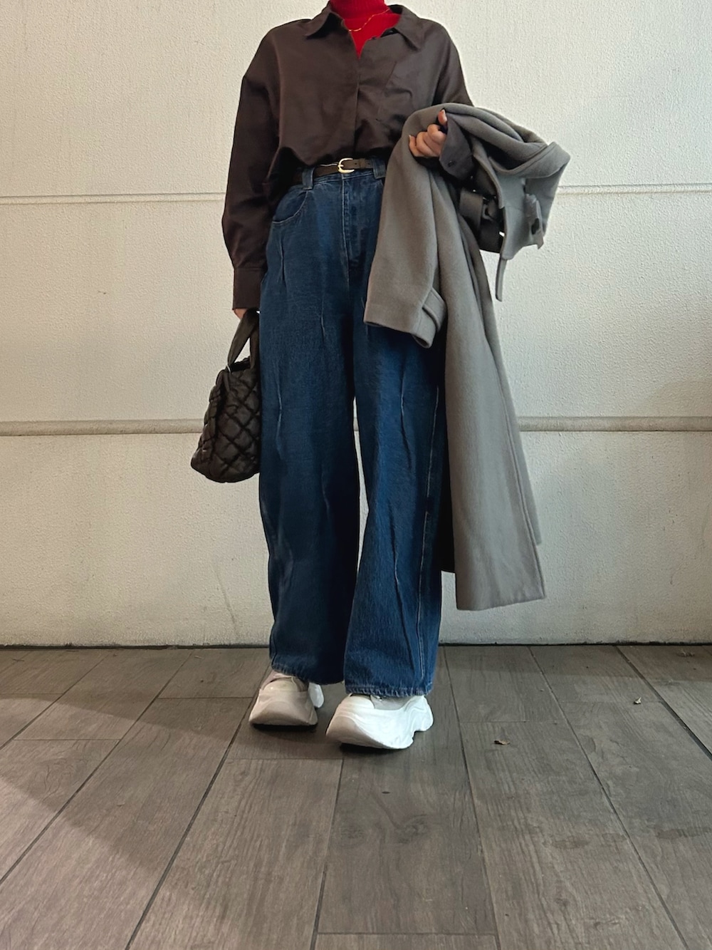 レッド系のニット/セーター、ブラウン系のショルダーバッグ、ベージュ系のその他アウターを着用したレディースの冬コーディネートの2枚目の写真