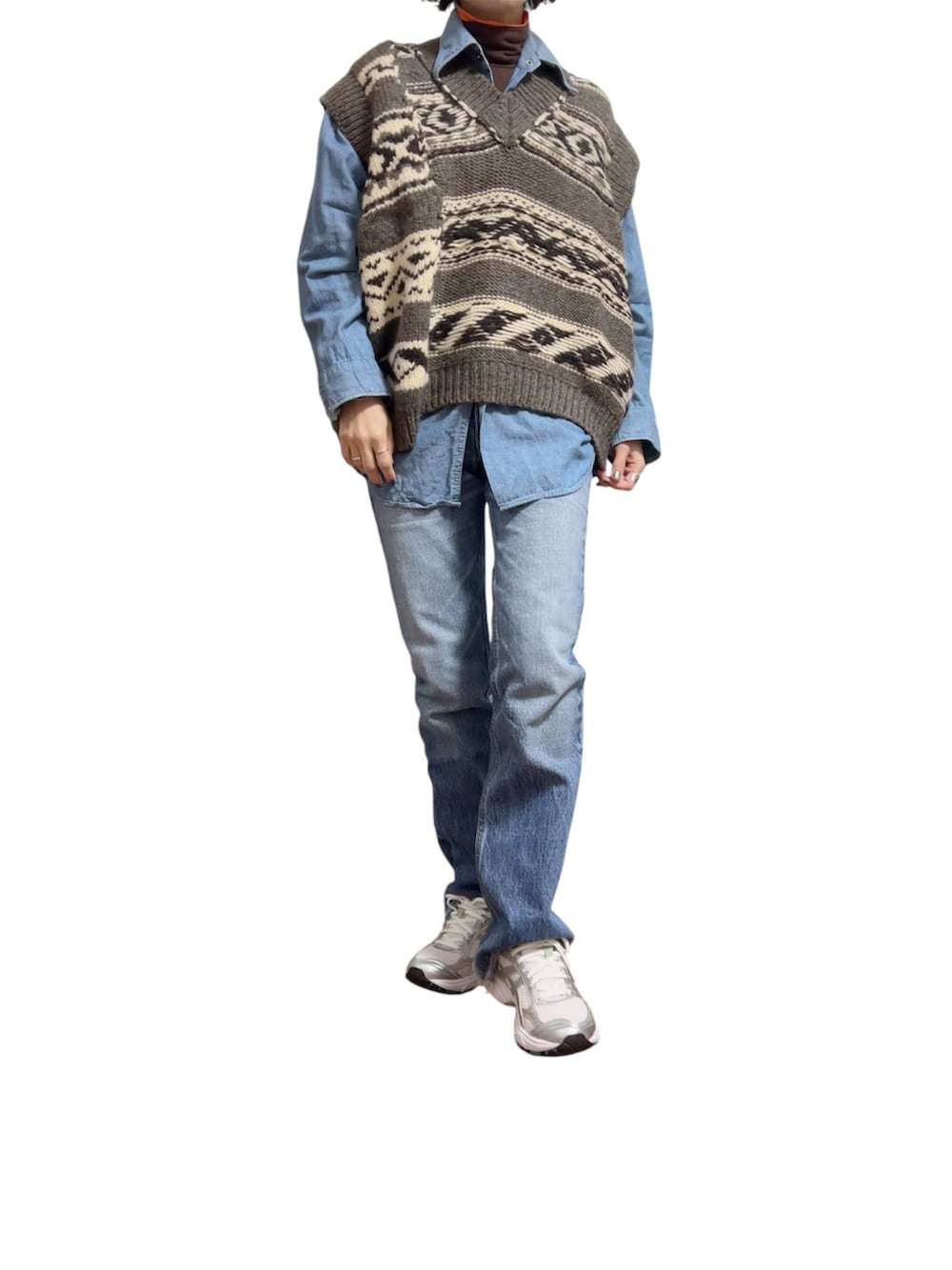 シルバー系のスニーカー、グレー系のベスト、ブラック系のジャケット/アウターを着用したレディースの冬コーディネートの2枚目の写真