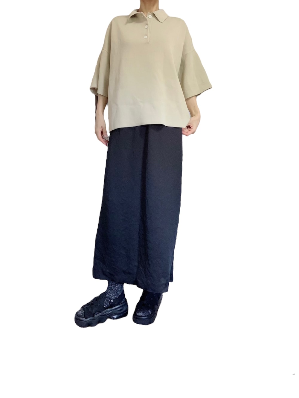 ベージュ系のポロシャツ、ブラック系のスカートを着用したレディースの夏コーディネートの2枚目の写真