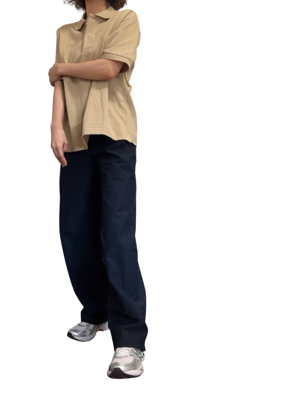 ベージュ系のポロシャツ、ブルー系のパンツ、シルバー系のスニーカーを着用したレディースの秋コーディネートの3枚目の写真