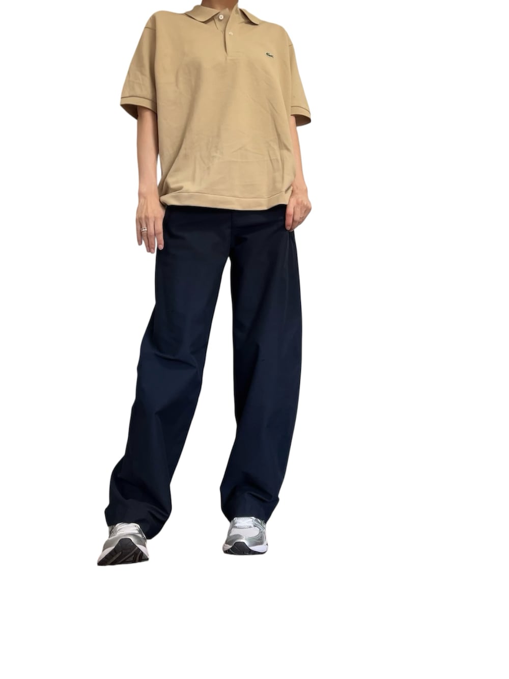 ベージュ系のポロシャツ、ブルー系のパンツ、シルバー系のスニーカーを着用したレディースの秋コーディネートの2枚目の写真