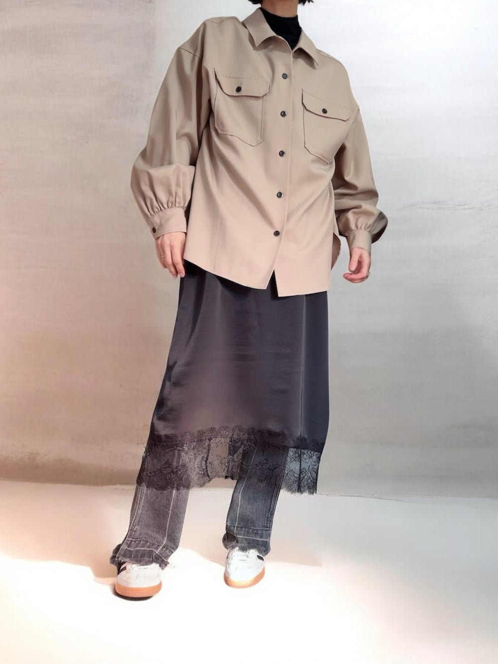 ベージュ系のシャツ/ブラウス、ブラック系のワンピース/ドレス、ブラック系のデニムパンツを着用したレディースの冬コーディネートの2枚目の写真