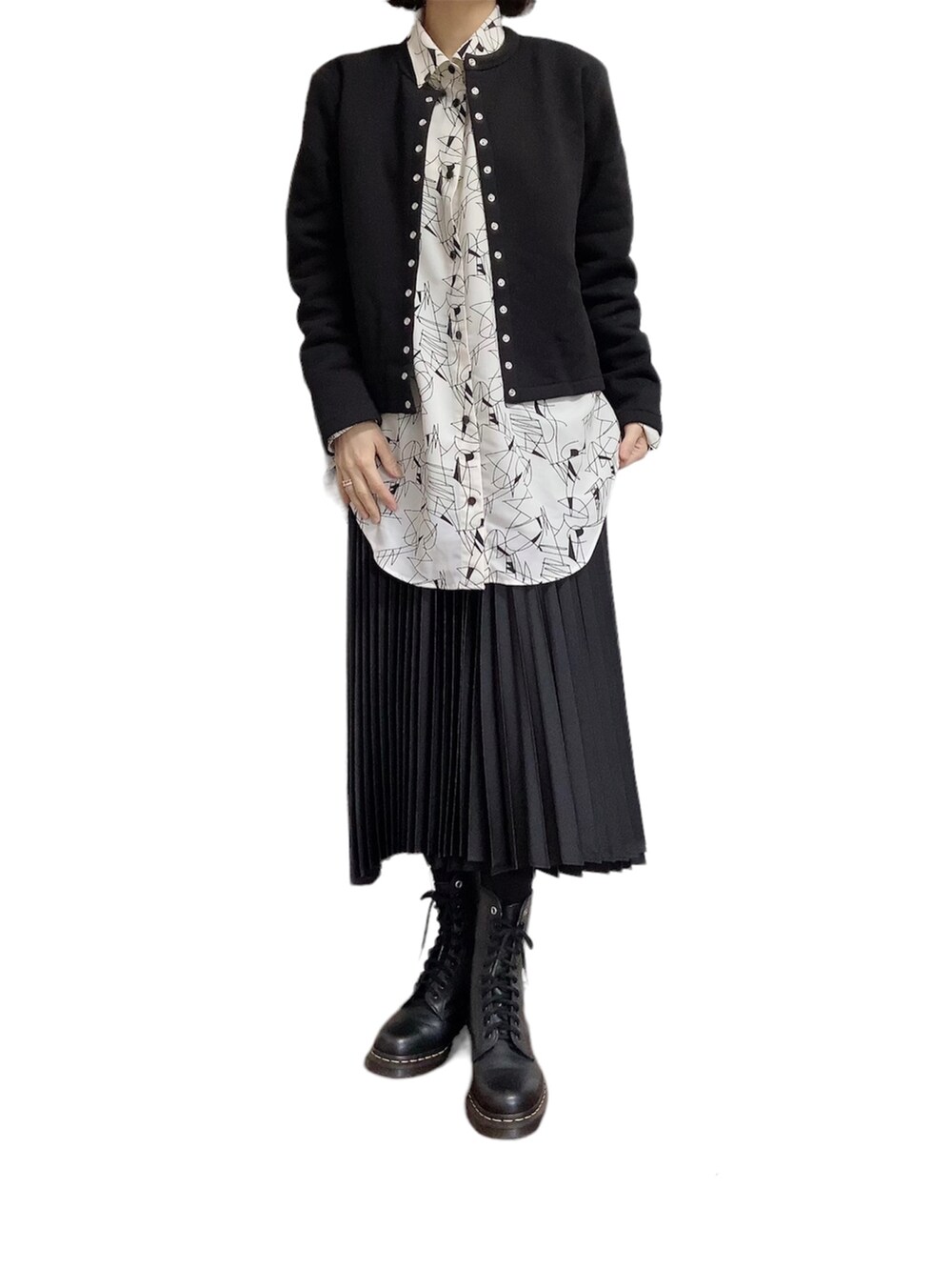 ホワイト系のシャツ/ブラウス、ブラック系のスカート、ブラック系のブーツを着用したレディースの春コーディネートの3枚目の写真