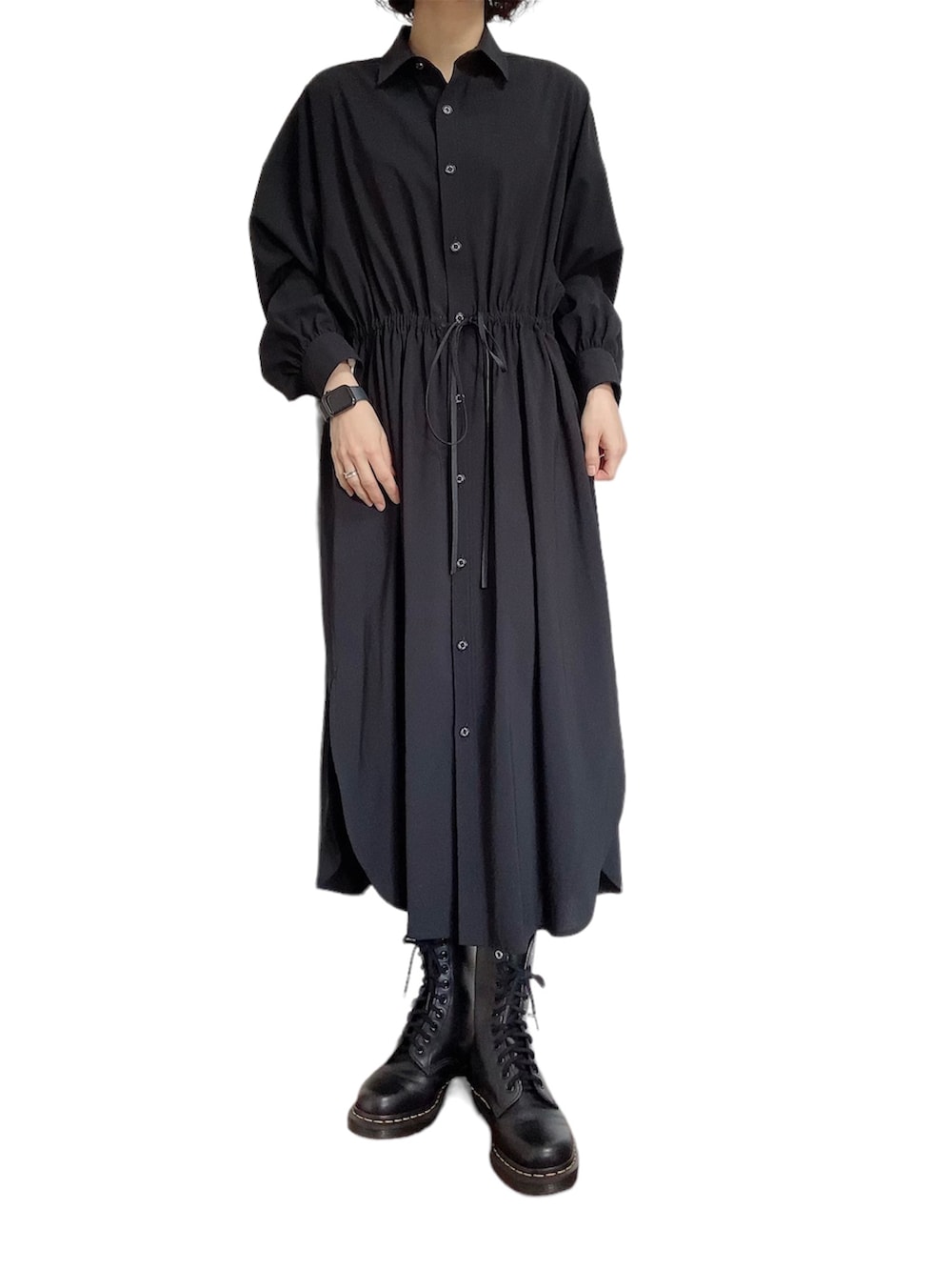 グレー系のテーラードジャケット、ブラック系のシャツワンピース、ブラック系のブーツを着用したレディースの春コーディネートの2枚目の写真