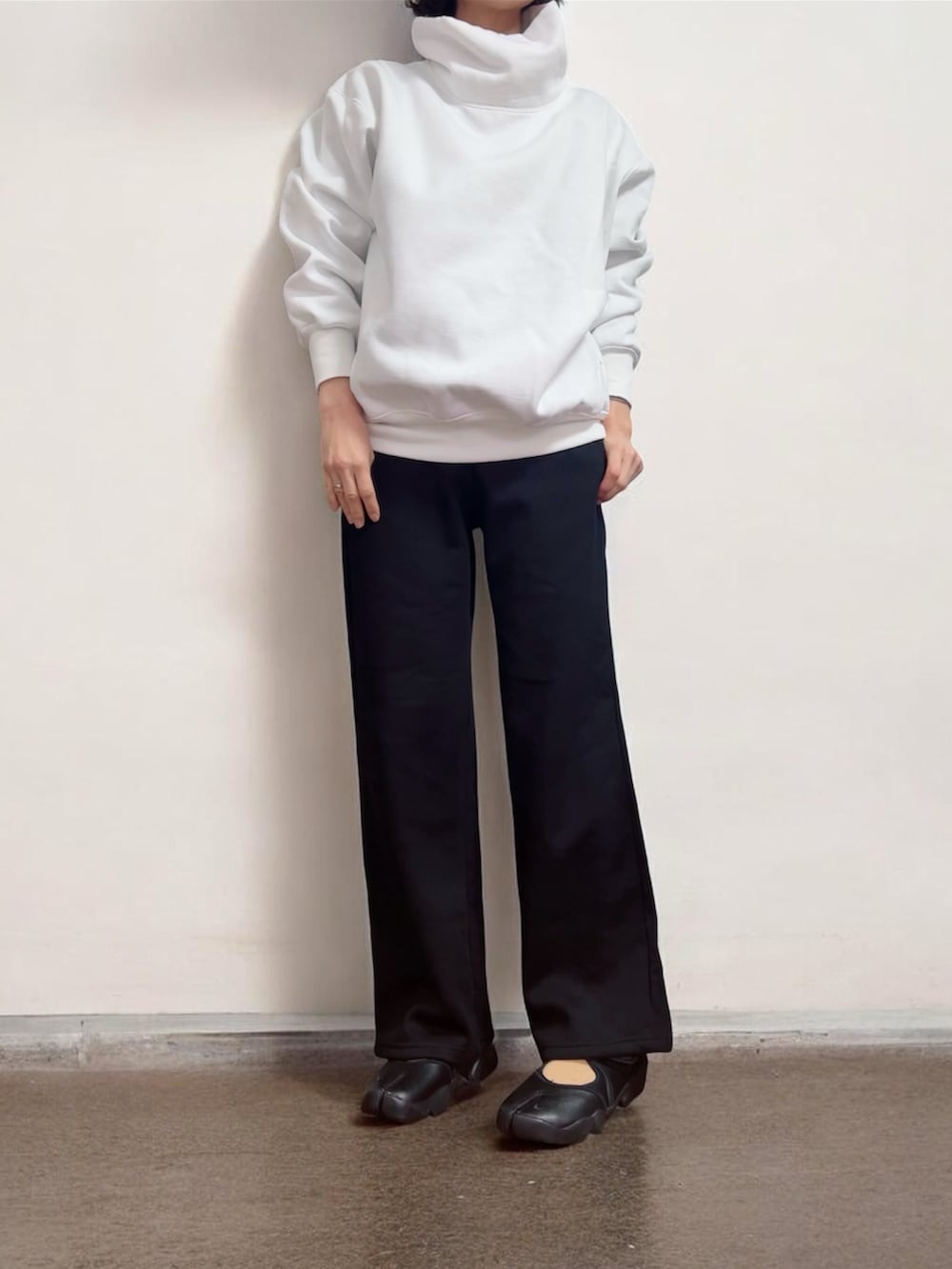 ホワイト系のスウェット、ブラック系のその他アウター、ブラック系のスニーカーを着用したレディースの冬コーディネートの2枚目の写真