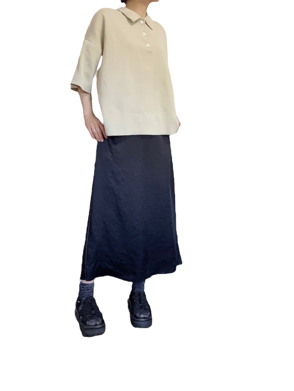 ベージュ系のポロシャツ、ブラック系のスカートを着用したレディースの夏コーディネートの3枚目の写真