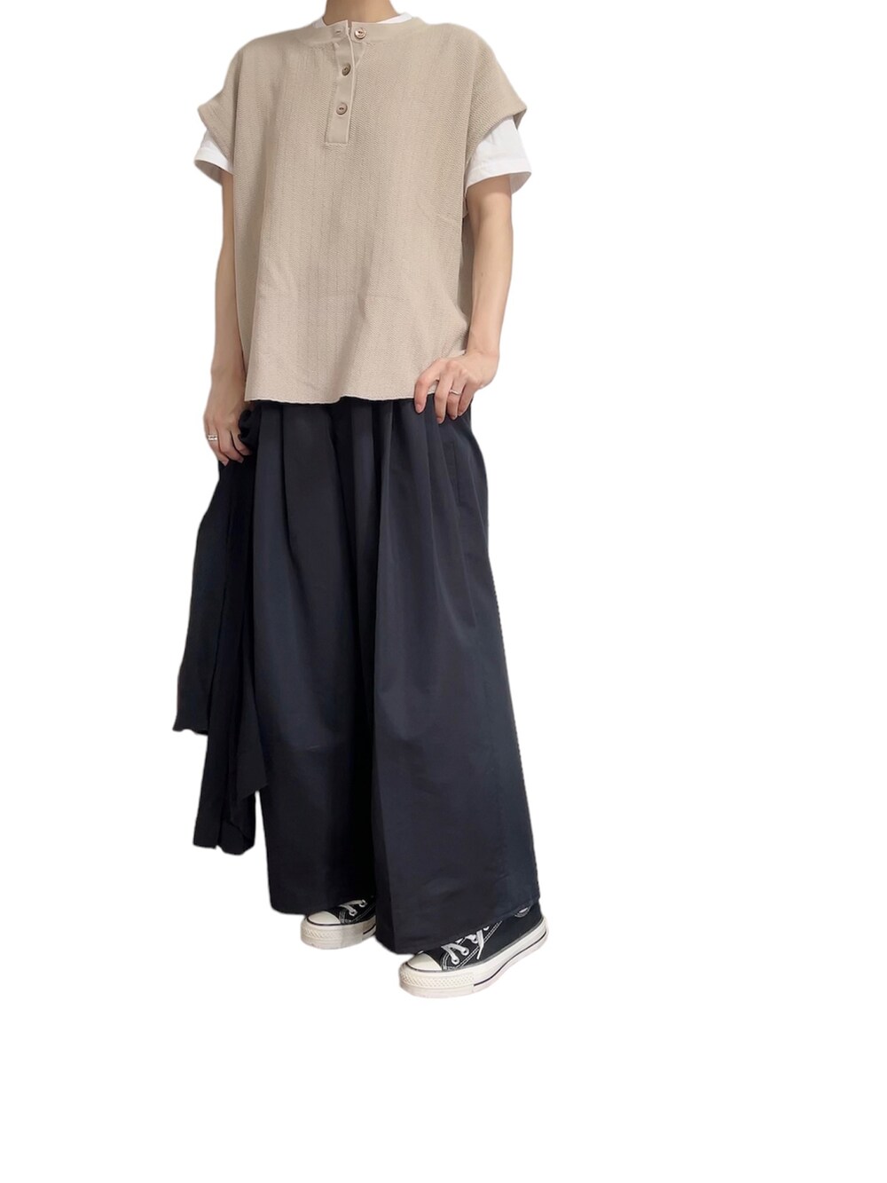 ベージュ系のニット/セーター、ブラック系のチノパンツ、ブラック系のスニーカーを着用したレディースの夏コーディネートの2枚目の写真