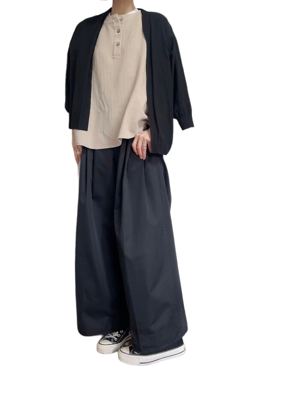 ベージュ系のニット/セーター、ブラック系のチノパンツ、ブラック系のスニーカーを着用したレディースの夏コーディネートの3枚目の写真