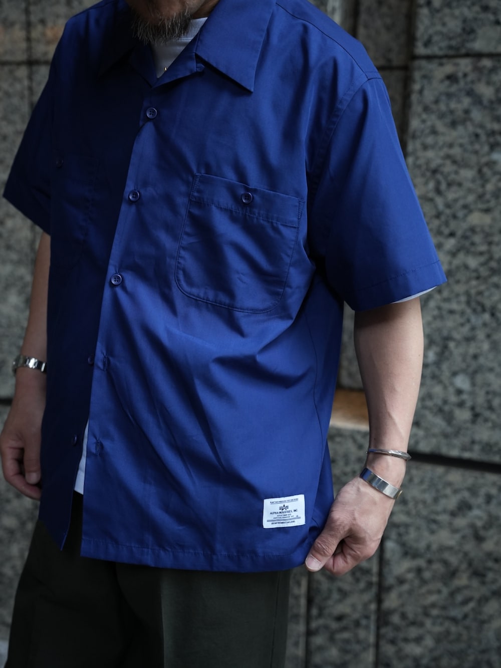 ブルー系のシャツ/ブラウス、ホワイト系のTシャツ/カットソー、グレー系のチノパンツを着用したメンズの夏コーディネートの6枚目の写真