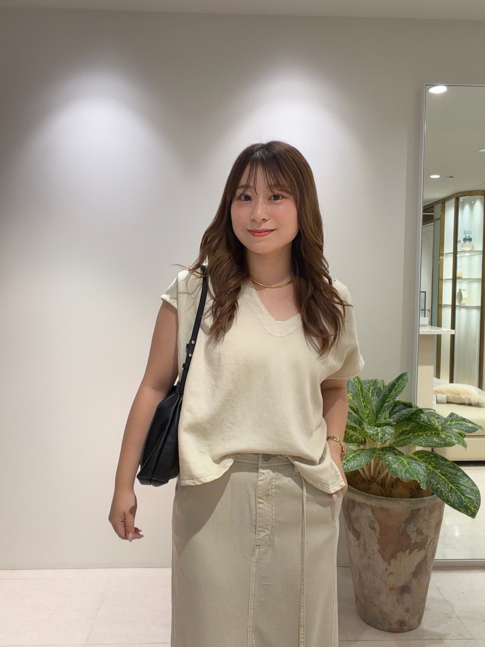 ベージュ系のシャツ/ブラウス、ベージュ系のスカート、ゴールド系のサンダルを着用したレディースの夏コーディネートの2枚目の写真
