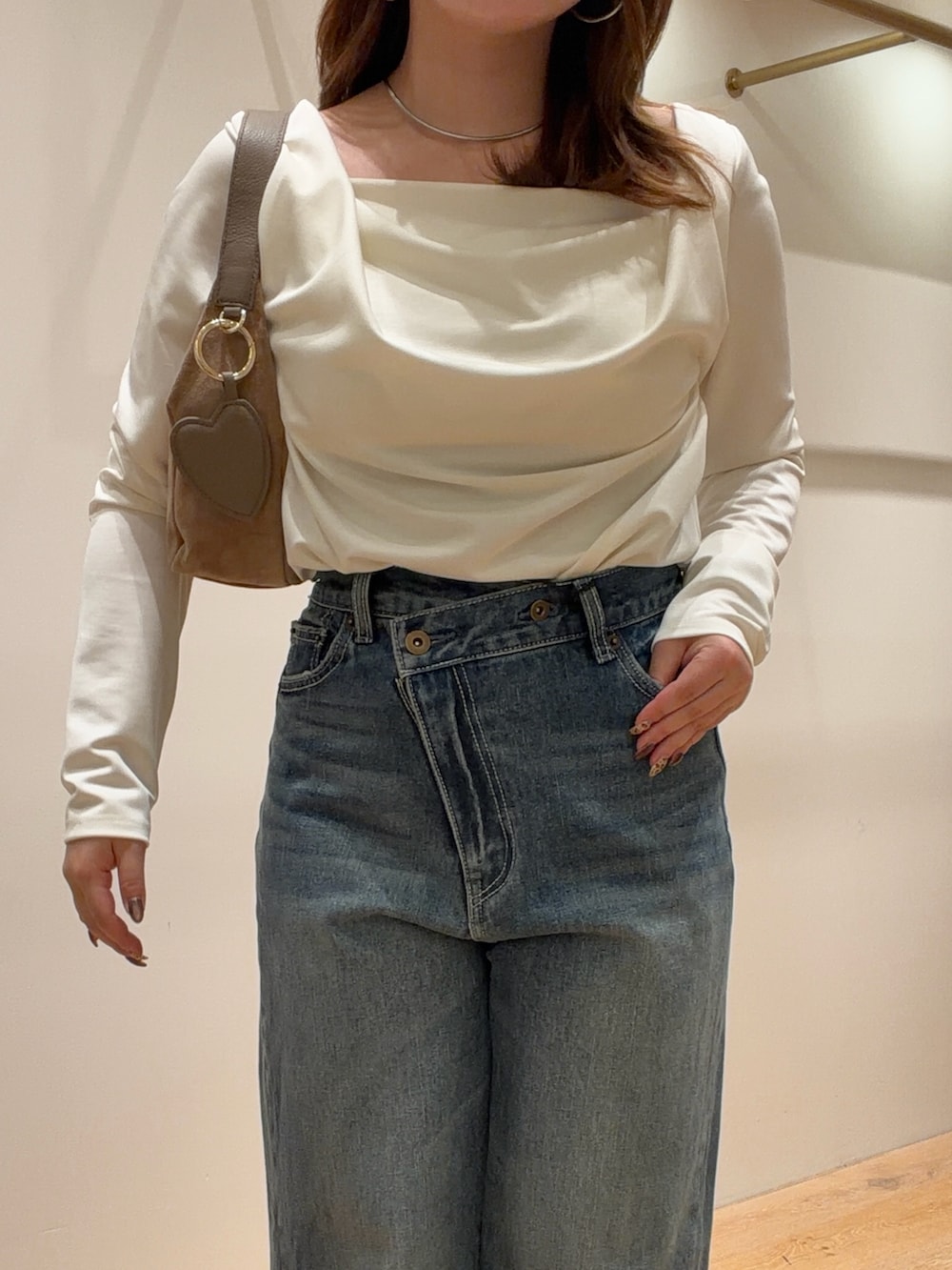 ホワイト系のTシャツ/カットソー、ブルー系のデニムパンツ、ブラック系のパンプスを着用したレディースの秋コーディネートの2枚目の写真